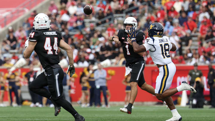 Nov 1, 2025; Houston, Texas, USA; Houston Cougars quarterback Conner Weigman (1) completes a pass to running back Dean Connors (44) as West Virginia Mountaineers linebacker Curtis Jones Jr. (18) rushes the quarterback  in the first half at TDECU Stadium. Mandatory Credit: Thomas Shea-Imagn Images