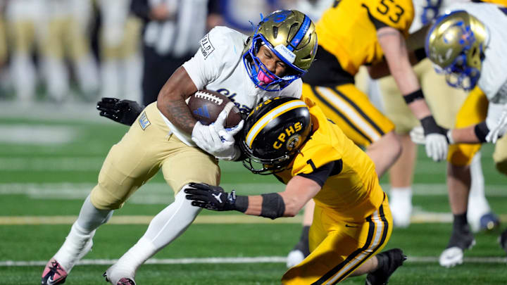 Choctaw's Mayor Morgan runs as Alex Dudley of Sand Springs tries to bring him down during the Class 6A-II high school football championship game at Chad Richison Stadium in Edmond, Oklahoma on Dec. 5, 2025.