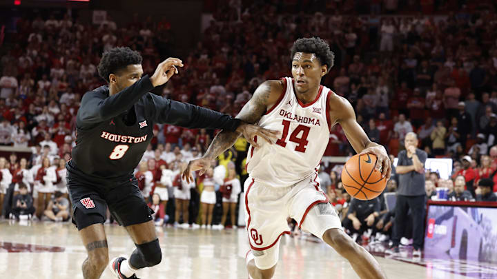 Mar 2, 2024; Norman, Oklahoma, USA; Oklahoma Sooners forward Jalon Moore (14) drives around Houston Cougars guard Mylik Wilson (8) during the second half at Lloyd Noble Center. Mandatory Credit: Alonzo Adams-Imagn Images