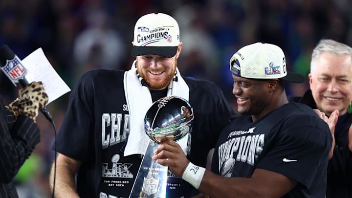 Seattle Seahawks quarterback Sam Darnold (14) and running back Kenneth Walker III (9) celebrate with the Vince Lombardi trophy after defeating the New England Patriots in Super Bowl LX at Levi's Stadium. 