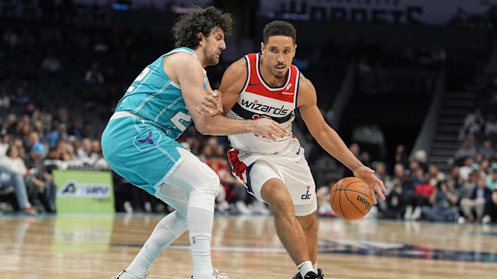 Feb 3, 2025; Charlotte, North Carolina, USA; Washington Wizards guard Malcolm Brogdon (15) on the dribble against Charlotte Hornets guard Vasilije Micic (22) during the second half at Spectrum Center. Mandatory Credit: Jim Dedmon-Imagn Images