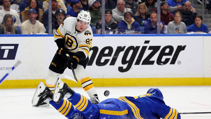 Apr 21, 2026; Buffalo, New York, USA; Buffalo Sabres defenseman Conor Timmins (21) tries to block a pass by Boston Bruins center Fraser Minten (93) during the first period in game two of the first round of the 2026 Stanley Cup Playoffs at KeyBank Center. Mandatory Credit: Timothy T. Ludwig-Imagn Images