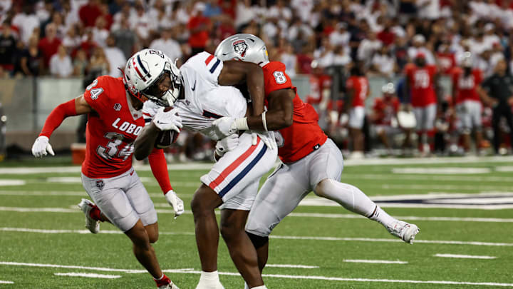 Aug 31, 2024; Tucson, Arizona, USA; Arizona Wildcats running back Jacory Croskey-Merritt (1) get tacked by New Mexico Lobos safety Christian Ellis (8) during third quarter at Arizona Stadium. Mandatory Credit: Aryanna Frank-Imagn Images