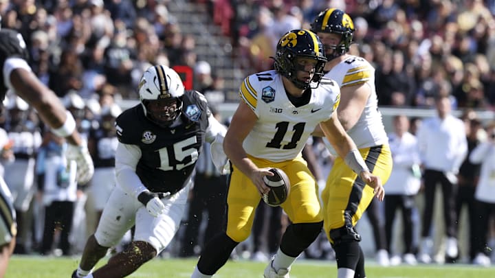 Dec 31, 2025; Tampa, FL, USA; Iowa Hawkeyes quarterback Mark Gronowski (11) scrambles out of the pocket against the Vanderbilt Commodores in the first quarter during the ReliaQuest Bowl at Raymond James Stadium. Mandatory Credit: Nathan Ray Seebeck-Imagn Images