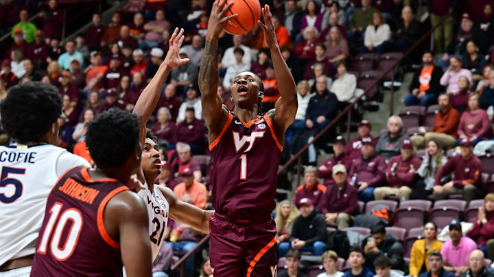 Feb 15, 2025; Blacksburg, Virginia, USA; Virginia Tech Hokies forward Tobi Lawal (1) shoots the ball as Virginia Cavaliers forward Anthony Robinson (21) defends during the first half at Cassell Coliseum. Mandatory Credit: Brian Bishop-Imagn Images