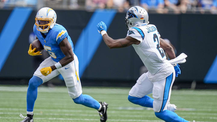 Sep 15, 2024; Charlotte, North Carolina, USA; Los Angeles Chargers wide receiver Joshua Palmer (5) tries to elude Carolina Panthers cornerback Michael Jackson (2) during the second half at Bank of America Stadium. Mandatory Credit: Jim Dedmon-Imagn Images
