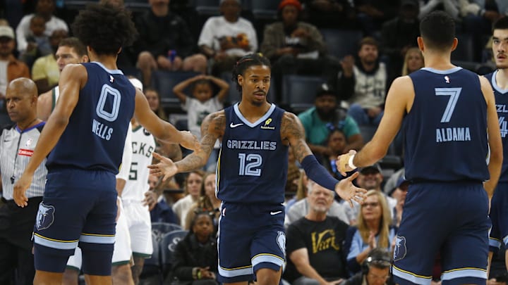 Oct 31, 2024; Memphis, Tennessee, USA; Memphis Grizzlies guard Ja Morant (12) reacts with forward Jaylen Wells (0) and forward Santi Aldama (7) during the first half against the Milwaukee Bucks at FedExForum. Mandatory Credit: Petre Thomas-Imagn Images