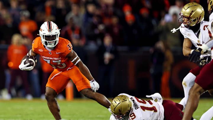 Oct 17, 2024; Blacksburg, Virginia, USA; Virginia Tech Hokies running back Bhayshul Tuten (33) runs the ball against Boston College Eagles cornerback Bryquice Brown (19) during the second quarter at Lane Stadium. Mandatory Credit: Peter Casey-Imagn Images
