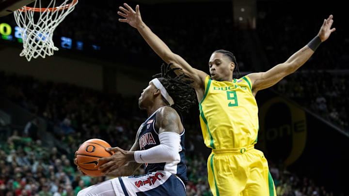 Arizona guard Caleb Love puts up a shot under cover from Oregon guard Keeshawn Barthelemy as the