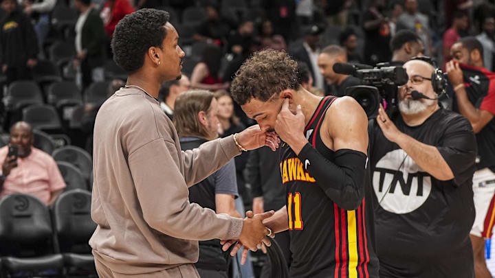 Apr 18, 2025; Atlanta, Georgia, USA; Atlanta Hawks guard Trae Young (11) reacts with injured player Kobe Bufkin after being defeated by the Miami Heat in overtime at State Farm Arena. Mandatory Credit: Dale Zanine-Imagn Images