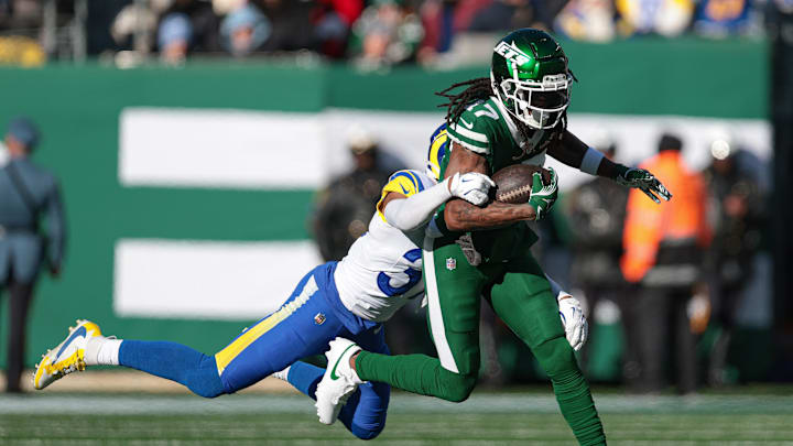 Dec 22, 2024; East Rutherford, New Jersey, USA; New York Jets wide receiver Davante Adams (17) fights for yards  as Los Angeles Rams safety Quentin Lake (37) tackles during the first half at MetLife Stadium. Mandatory Credit: Vincent Carchietta-Imagn Images