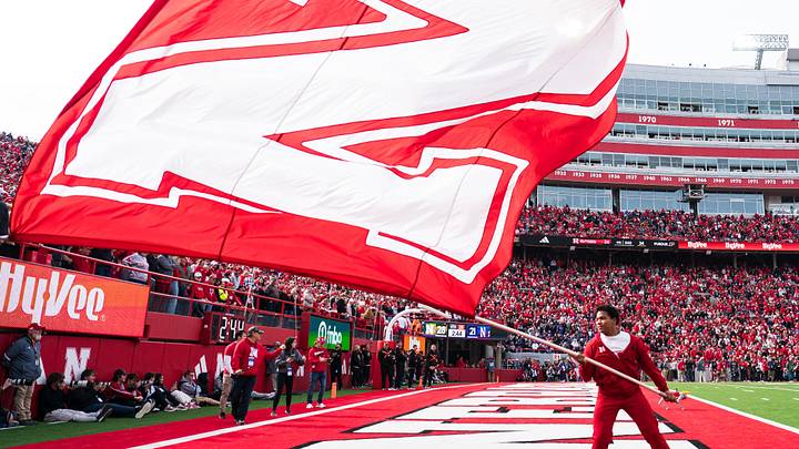 Oct 25, 2025; Lincoln, Nebraska, USA; A Nebraska Cornhuskers cheerleader waves a school flag after a touchdown against the Northwestern Wildcats during the fourth quarter at Memorial Stadium. Mandatory Credit: Dylan Widger-Imagn Images Oct 25, 2025; Lincoln, Nebraska, USA; A Nebraska Cornhuskers cheerleader waves a school flag after a touchdown against the Northwestern Wildcats during the fourth quarter at Memorial Stadium. Mandatory Credit: Dylan Widger-Imagn Images