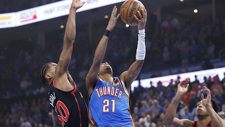 Feb 7, 2025; Oklahoma City, Oklahoma, USA; Oklahoma City Thunder guard Aaron Wiggins (21) goes to the basket beside Toronto Raptors guard Ochai Agbaji (30) during the first quarter at Paycom Center. Mandatory Credit: Alonzo Adams-Imagn Images