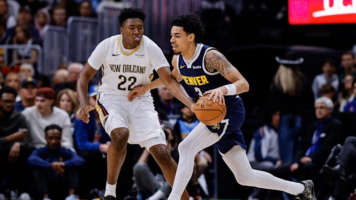 Oct 29, 2025; Denver, Colorado, USA; Denver Nuggets guard Julian Strawther (3) controls the ball as New Orleans Pelicans center Derik Queen (22) defends in the second quarter at Ball Arena. Mandatory Credit: Isaiah J. Downing-Imagn Images