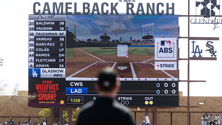 Mar 2, 2025; Phoenix, Arizona, USA; An umpire looks at the Jumbotron during an automated ball-strike challenge aka ABS in the Los Angeles Dodgers game against the Chicago White Sox during spring training at Camelback Ranch-Glendale. Mandatory Credit: Mark J. Rebilas-Imagn Images