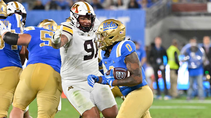 Oct 12, 2024; Pasadena, California, USA; Minnesota Golden Gophers defensive lineman Deven Eastern (91) moves in to stop UCLA Bruins running back Jalen Berger during the fourth quarter at the Rose Bowl. Mandatory Credit: Robert Hanashiro-Imagn Images