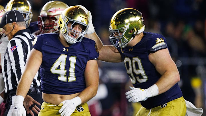 Notre Dame defensive lineman Rylie Mills (99) and defensive lineman Donovan Hinish (41) celebrate getting a stop during a NCAA college football game against Florida State at Notre Dame Stadium on Saturday, Nov. 9, 2024, in South Bend.