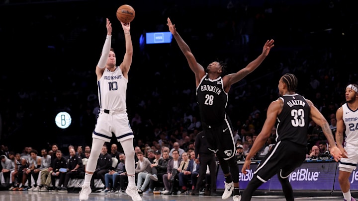 Mar 4, 2024; Brooklyn, New York, USA; Memphis Grizzlies guard Luke Kennard (10) shoots a three point shot against Brooklyn Nets forward Dorian Finney-Smith (28) and center Nic Claxton (33) during the fourth quarter at Barclays Center. Mandatory Credit: Brad Penner-Imagn Images