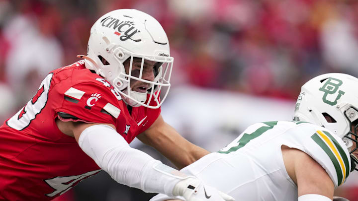 Oct 25, 2025; Cincinnati, Ohio, USA;  Cincinnati Bearcats linebacker Jack Dingle (49) tackles Baylor Bears quarterback Sawyer Robertson (13) in the first half at Nippert Stadium. Mandatory Credit: Aaron Doster-Imagn Images