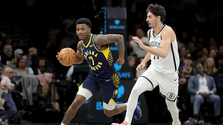 Feb 11, 2026; Brooklyn, New York, USA; Indiana Pacers guard Kam Jones (7) brings the ball up court against Brooklyn Nets guard Ben Saraf (77) during the third quarter at Barclays Center. Mandatory Credit: Brad Penner-Imagn Images