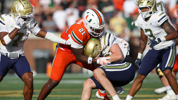 Nov 9, 2024; Atlanta, Georgia, USA; Miami Hurricanes linebacker Jaylin Alderman (21) tackles Georgia Tech Yellow Jackets quarterback Haynes King (10) in the fourth quarter at Bobby Dodd Stadium at Hyundai Field. Mandatory Credit: Brett Davis-Imagn Images