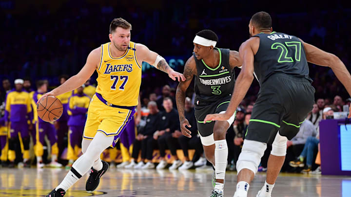 Apr 30, 2025; Los Angeles, California, USA; Los Angeles Lakers guard Luka Doncic (77) moves the ball against Minnesota Timberwolves forward Jaden McDaniels (3) and center Rudy Gobert (27) during the first half in game five of first round for the 2025 NBA Playoffs at Crypto.com Arena. Mandatory Credit: Gary A. Vasquez-Imagn Images Apr 30, 2025; Los Angeles, California, USA; Los Angeles Lakers guard Luka Doncic (77) moves the ball against Minnesota Timberwolves forward Jaden McDaniels (3) and center Rudy Gobert (27) during the first half in game five of first round for the 2025 NBA Playoffs at Crypto.com Arena. Mandatory Credit: Gary A. Vasquez-Imagn Images