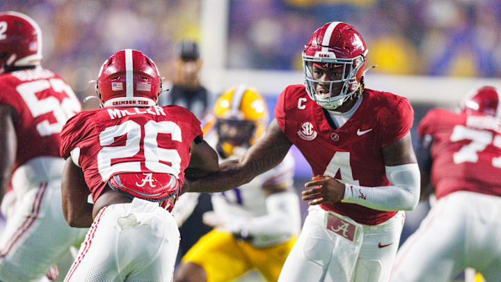 Nov 9, 2024; Baton Rouge, Louisiana, USA;  Alabama Crimson Tide quarterback Jalen Milroe (4) hands the ball off to Alabama Crimson Tide running back Jam Miller (26) against the LSU Tigers at Tiger Stadium. Mandatory Credit: Stephen Lew-Imagn Images