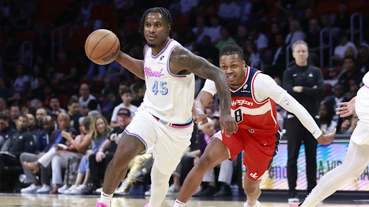 Apr 13, 2025; Miami, Florida, USA;  Miami Heat guard Davion Mitchell (45) passes in front of Washington Wizards guard Bub Carrington (8) during the first half at Kaseya Center. Mandatory Credit: Rhona Wise-Imagn Images