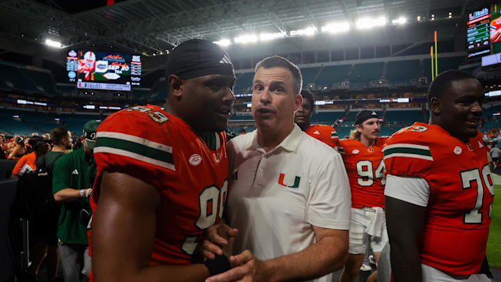 Sep 13, 2025; Miami Gardens, Florida, USA; Miami Hurricanes head coach Mario Cristobal celebrates with defensive lineman Ahmad Moten Sr. (99) after the game against the South Florida Bulls at Hard Rock Stadium. Mandatory Credit: Sam Navarro-Imagn Images