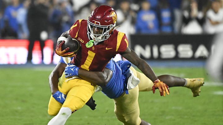 Nov 23, 2024; Pasadena, California, USA; USC Trojans wide receiver Zachariah Branch (1) is tackled by UCLA Bruins linebacker Jalen Woods (17) during the second quarter at Rose Bowl. Mandatory Credit: Robert Hanashiro-Imagn Images