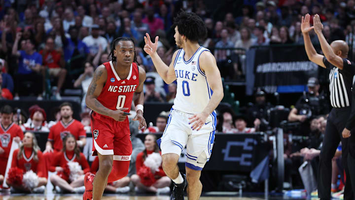Mar 31, 2024; Dallas, TX, USA; Duke Blue Devils guard Jared McCain (0) and North Carolina State Wolfpack guard DJ Horne (0) react in the first half in the finals of the South Regional of the 2024 NCAA Tournament at American Airline Center. Mandatory Credit: Tim Heitman-USA TODAY Sports