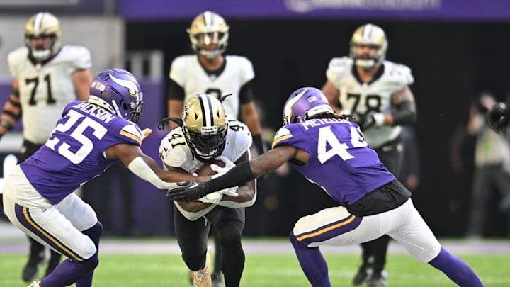 Nov 12, 2023; Minneapolis, Minnesota, USA; New Orleans Saints running back Alvin Kamara (41) is tackled by Minnesota Vikings safety Theo Jackson (25) and safety Josh Metellus (44) during the fourth quarter at U.S. Bank Stadium. Mandatory Credit: Jeffrey Becker-Imagn Images