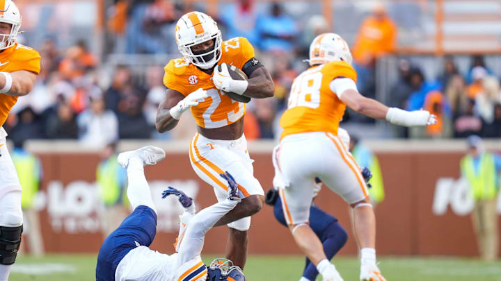 Nov 23, 2024; Knoxville, Tennessee, USA; Tennessee Volunteers running back Cameron Seldon (23) jumps over UTEP Miners safety Oscar Moore (11) at Neyland Stadium. Mandatory Credit: Angelina Alcantar/USA TODAY Network via Imagn Images