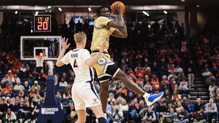 Feb 8, 2025; Charlottesville, Virginia, USA; Georgia Tech Yellow Jackets forward Darrion Sutton (10) catches the ball while Virginia Cavaliers guard Andrew Rohde (4) defends during the first half at John Paul Jones Arena. Mandatory Credit: Emily Faith Morgan-Imagn Images