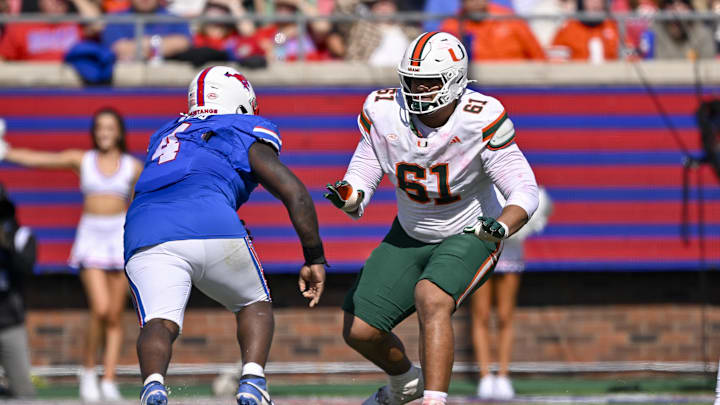 Nov 1, 2025; Dallas, Texas, USA;  Miami Hurricanes offensive lineman Francis Mauigoa (61) blocks SMU Mustangs defensive tackle Terry Webb (4) during the game between the Mustangs and the Hurricanes at Gerald J. Ford Stadium. Mandatory Credit: Jerome Miron-Imagn Images