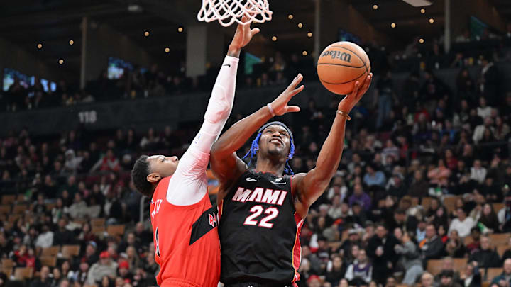 Dec 1, 2024; Toronto, Ontario, CAN;  Miami Heat forward Jimmy Butler (22) shoots the ball as Toronto Raptors forward RJ Barrett (9) defends in the first half at Scotiabank Arena. Mandatory Credit: Dan Hamilton-Imagn Images