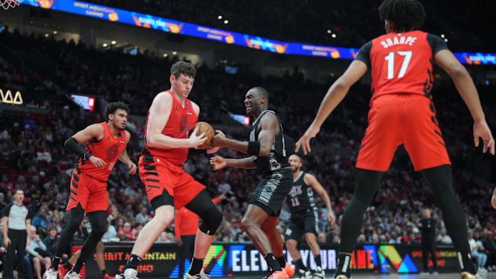 Apr 6, 2025; Portland, Oregon, USA; Portland Trail Blazers center Donovan Clingan (23, left) grabs the ball against San Antonio Spurs center Bismack Biyombo (18) during the first half at Moda Center. Mandatory Credit: Soobum Im-Imagn Images Apr 6, 2025; Portland, Oregon, USA; Portland Trail Blazers center Donovan Clingan (23, left) grabs the ball against San Antonio Spurs center Bismack Biyombo (18) during the first half at Moda Center. Mandatory Credit: Soobum Im-Imagn Images