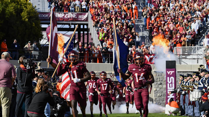 Nov 1, 2025; Blacksburg, Virginia, USA;  Virginia Tech Hokies safety Tyson Flowers (11) and safety Sheldon Robinson (14) run into the stadium before the game against the Louisville Cardinals at Lane Stadium. Mandatory Credit: Brian Bishop-Imagn Images