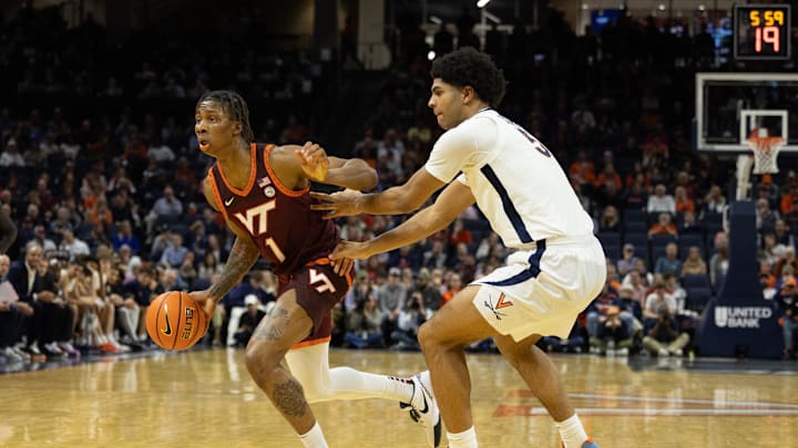 Feb 1, 2025; Charlottesville, Virginia, USA; Virginia Tech Hokies forward Tobi Lawal (1) dribbles the ball as Virginia Cavaliers forward Jacob Cofie (5) defends at John Paul Jones Arena. Mandatory Credit: Emily Morgan-Imagn Images