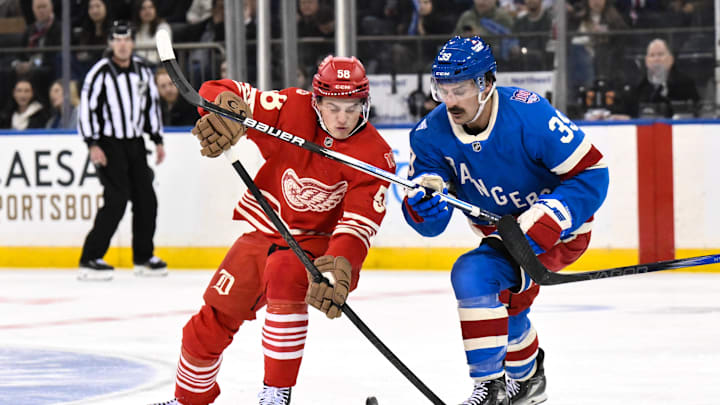 Nov 16, 2025; New York, New York, USA; Detroit Red Wings center Emmitt Finnie (58) and New York Rangers center Sam Carrick (39) compete for the puck during the second period at Madison Square Garden. Mandatory Credit: John Jones-Imagn Images