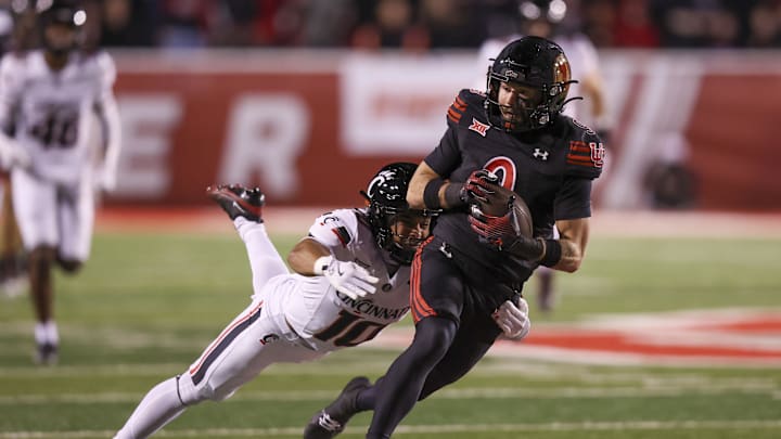 Utah Utes wide receiver Ryan Davis (9) is tackled after a catch by Cincinnati Bearcats safety Tayden Barnes (10) during the second quarter at Rice-Eccles Stadium. 