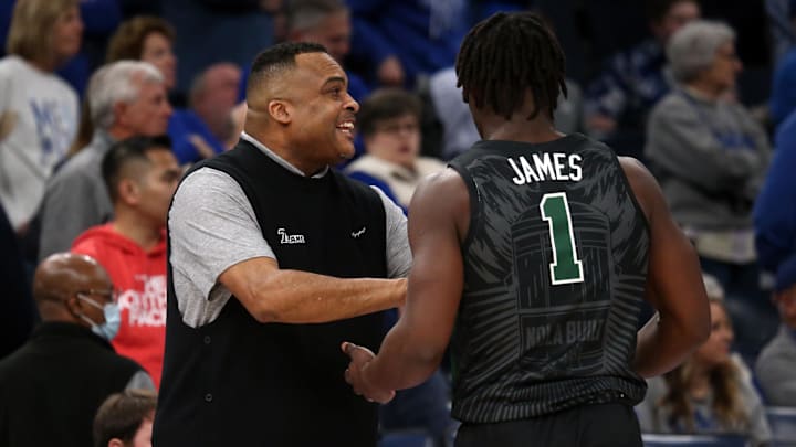 Feb 11, 2024; Memphis, Tennessee, USA; Tulane Green Wave head coach Ron Hunter (left) talks with Tulane Green Wave guard Sion James (1) during the first half against the Memphis Tigers at FedExForum. 