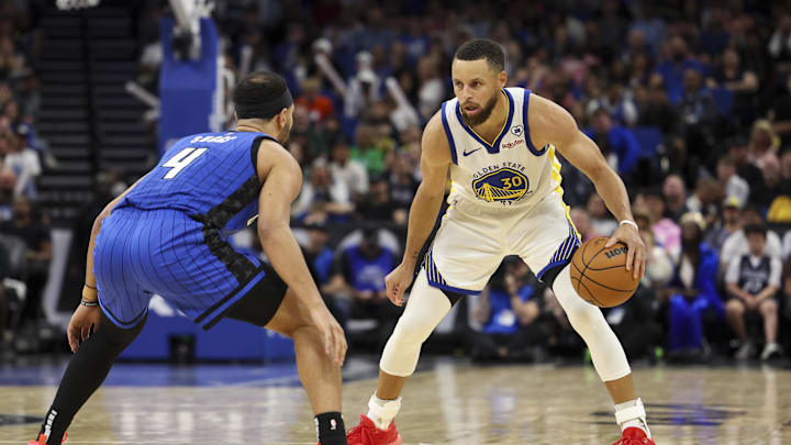   Orlando Magic guard Jalen Suggs (4) guards Golden State Warriors guard Stephen Curry (30) in the fourth quarter at the Kia Center. Mandatory Credit: Nathan Ray Seebeck-Imagn Images