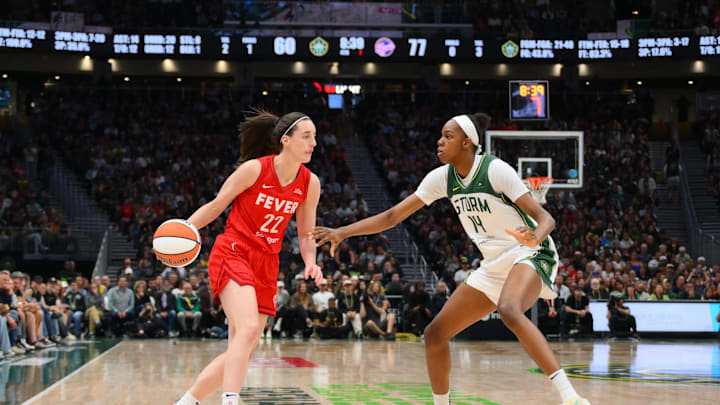 Jun 24, 2025; Seattle, Washington, USA; Indiana Fever guard Caitlin Clark (22) dribbles the ball while guarded by Seattle Storm center Dominique Malonga (14) during the second half at Climate Pledge Arena. Mandatory Credit: Steven Bisig-Imagn Images