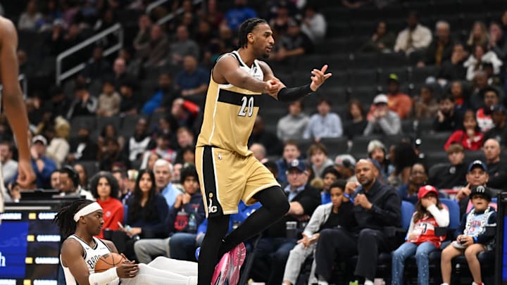 Nov 16, 2025; Washington, District of Columbia, USA;  Washington Wizards center Alex Sarr (20) reacts to a foul call in front of Brooklyn Nets guard Terance Mann (14) during the fourth quarter at Capital One Arena. Mandatory Credit: Rafael Suanes-Imagn Images