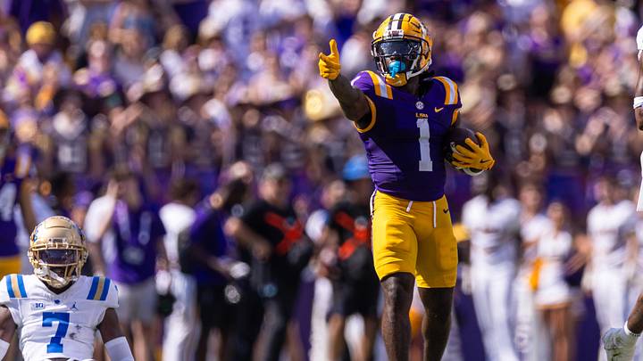 Sep 21, 2024; Baton Rouge, Louisiana, USA;  LSU Tigers wide receiver Aaron Anderson (1) reacts after making a first down against UCLA Bruins defensive back K.J. Wallace (7) during the first half at Tiger Stadium. Mandatory Credit: Stephen Lew-Imagn Images
