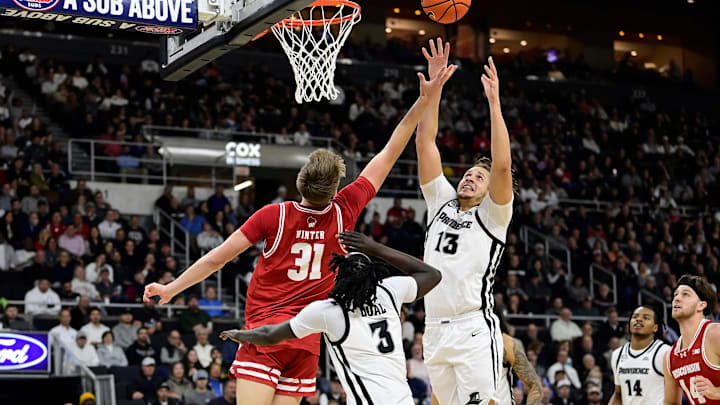 Nov 14, 2023; Providence, Rhode Island, USA; Providence Friars forward Josh Oduro (13) leaps for a rebound over Wisconsin Badgers forward Nolan Winter during the second half against the Wisconsin Badgers at Amica Mutual Pavilion.