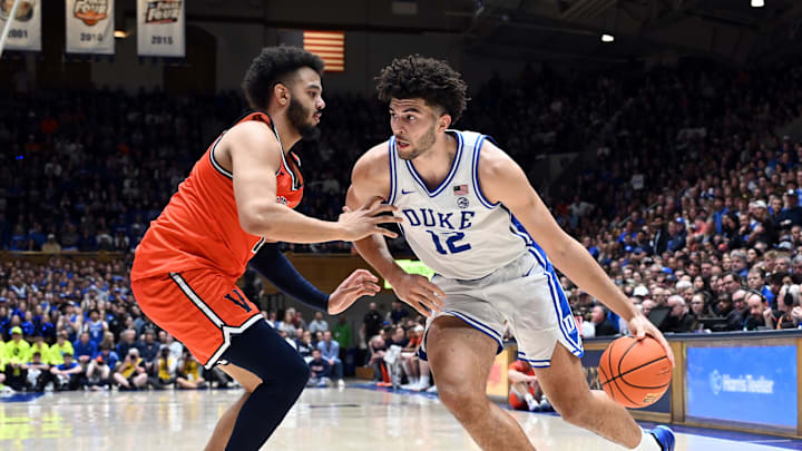Feb 28, 2026; Durham, North Carolina, USA; Duke Blue Devils forward Cameron Boozer (12) drives to the basket as Virginia Cavaliers forward Devin Tillis (11) defends during the second half at Cameron Indoor Stadium.   Duke won 77-51.  Mandatory Credit: Rob Kinnan-Imagn Images