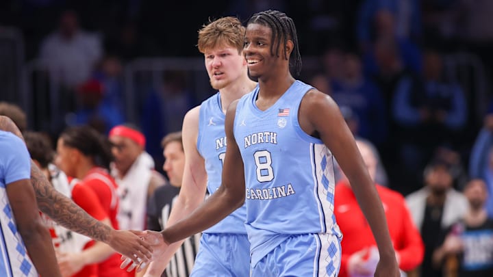 Dec 20, 2025; Atlanta, Georgia, USA; North Carolina Tar Heels forward Caleb Wilson (8) and center Henri Veesaar (13) celebrate during a timeout against the Ohio State Buckeyes in the second half at State Farm Arena. Mandatory Credit: Brett Davis-Imagn Images
