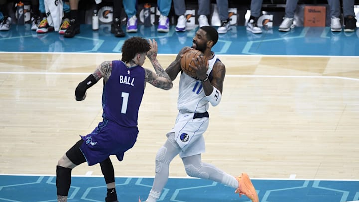 Jan 20, 2025; Charlotte, North Carolina, USA;  Dallas Mavericks guard Kyrie Irving (11) drives past Charlotte Hornets guard LaMelo Ball (1) during the second half at the Spectrum Center. Mandatory Credit: Sam Sharpe-Imagn Images